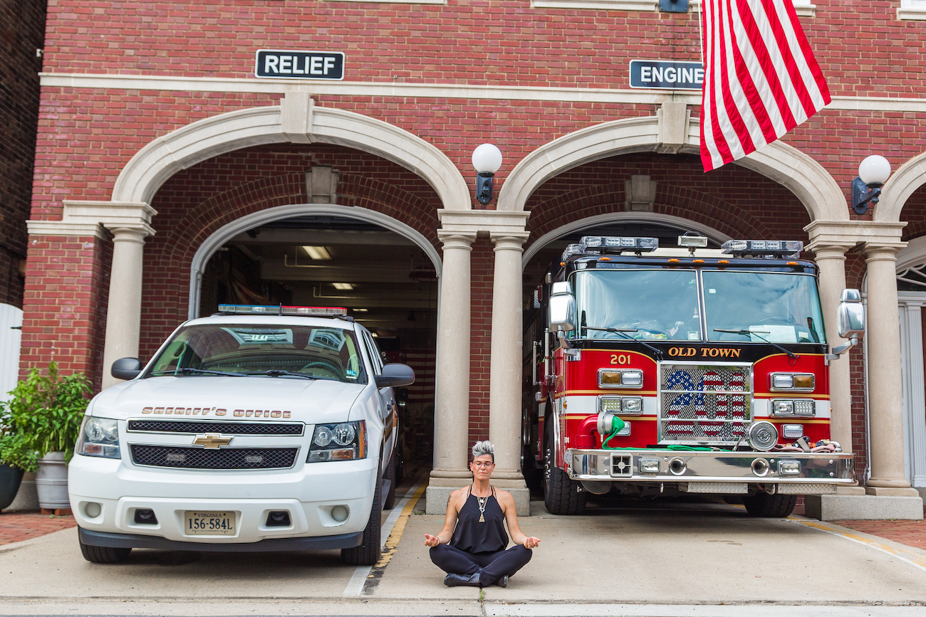 Gina sitting in front of firetrucks at a fire station
