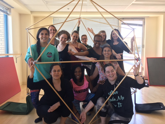 Students pose inside a hexahedron-shaped structure.