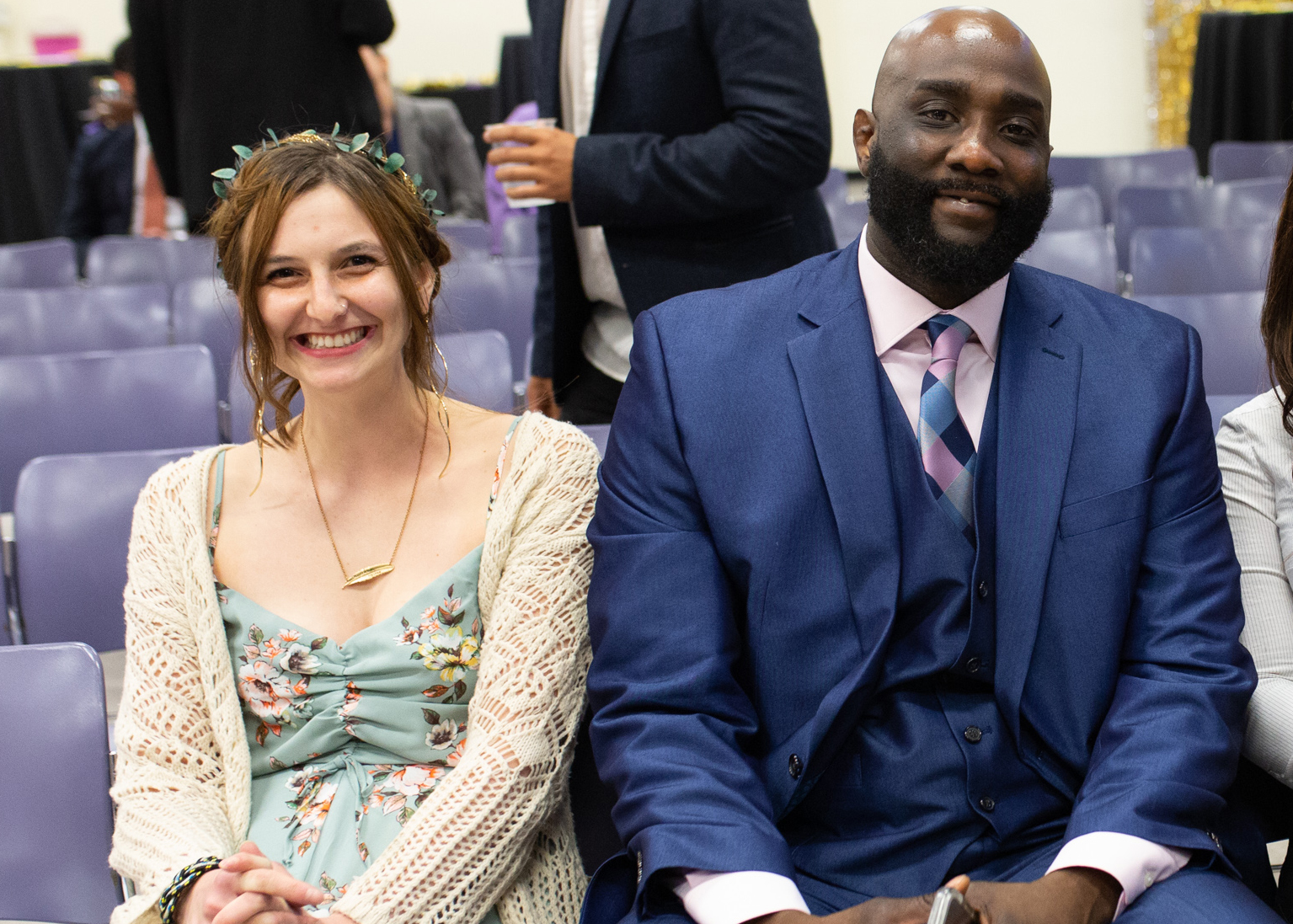 Katya Zinn and Tyrell Dortch are seated next to each other and smiling at the camera.