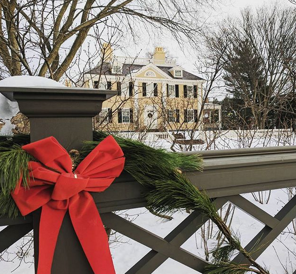 Cambridge mansion covered in snow and decorated for Christmas.