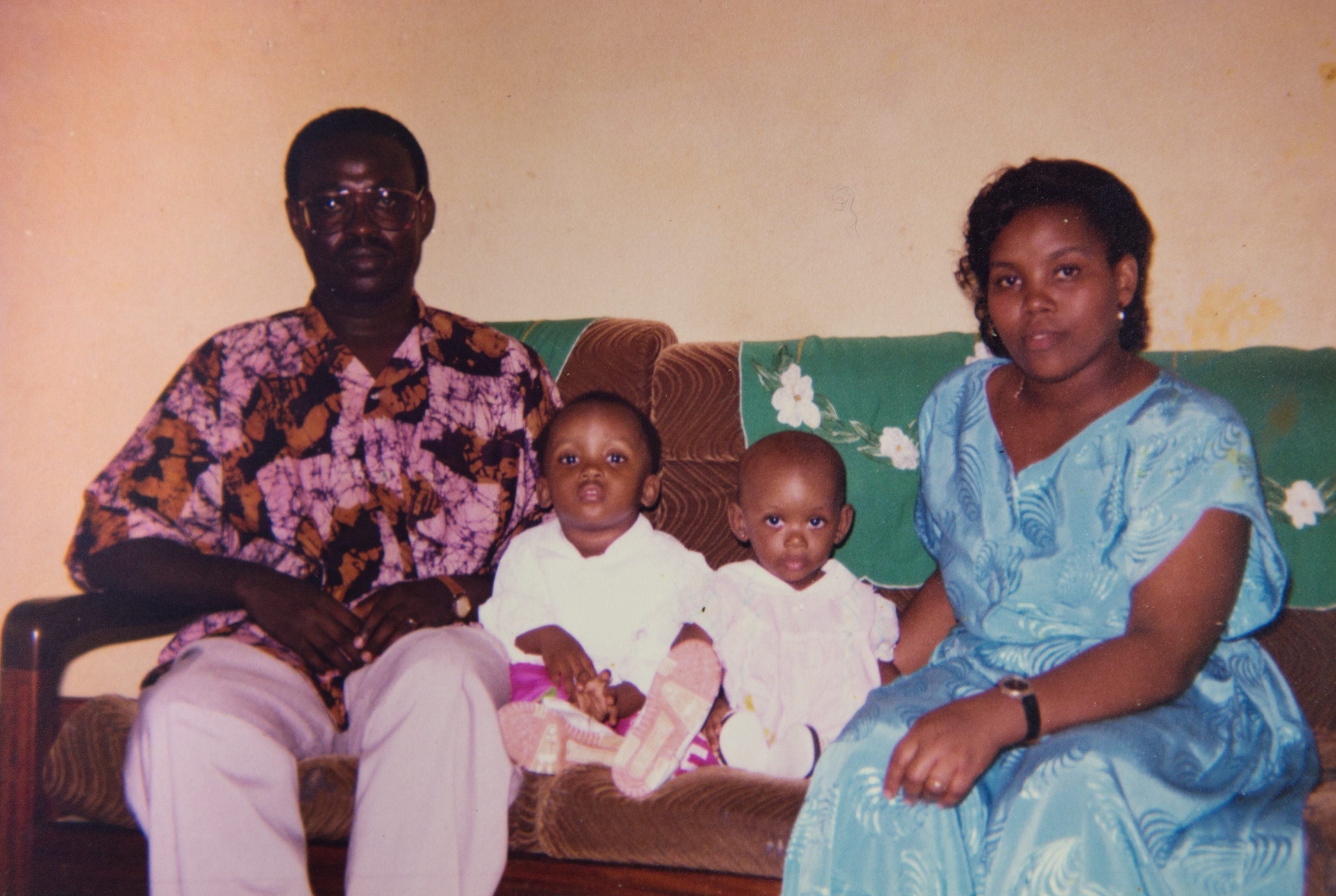 Marie Ntawizera, her husband and her two daughters sitting on a couch.