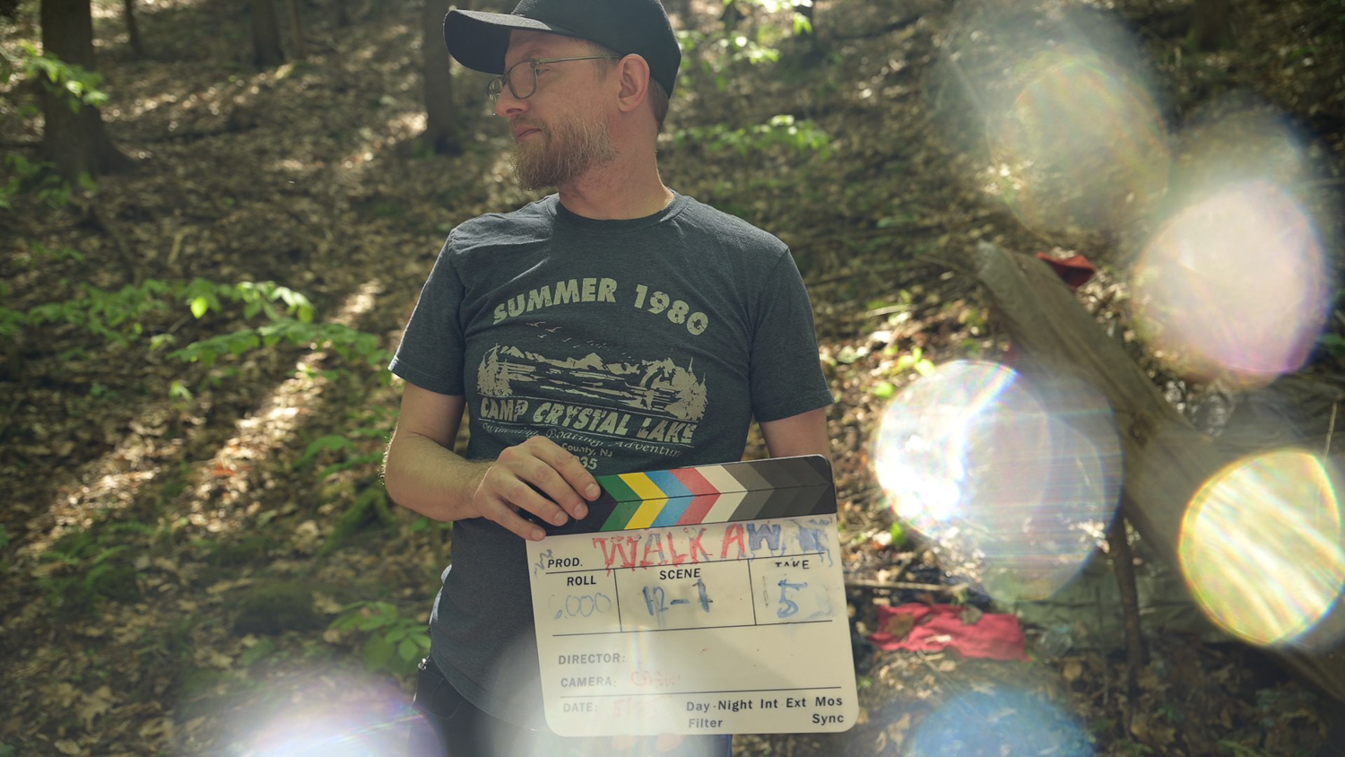Matthew Nash holding a clapperboard that says "Walk Away"