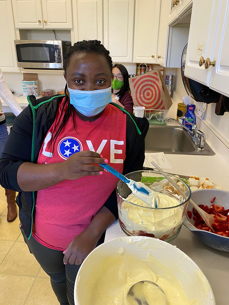 Demi Muhorakeye prepares strawberry trifle in the Threshold Program Food Lab course.