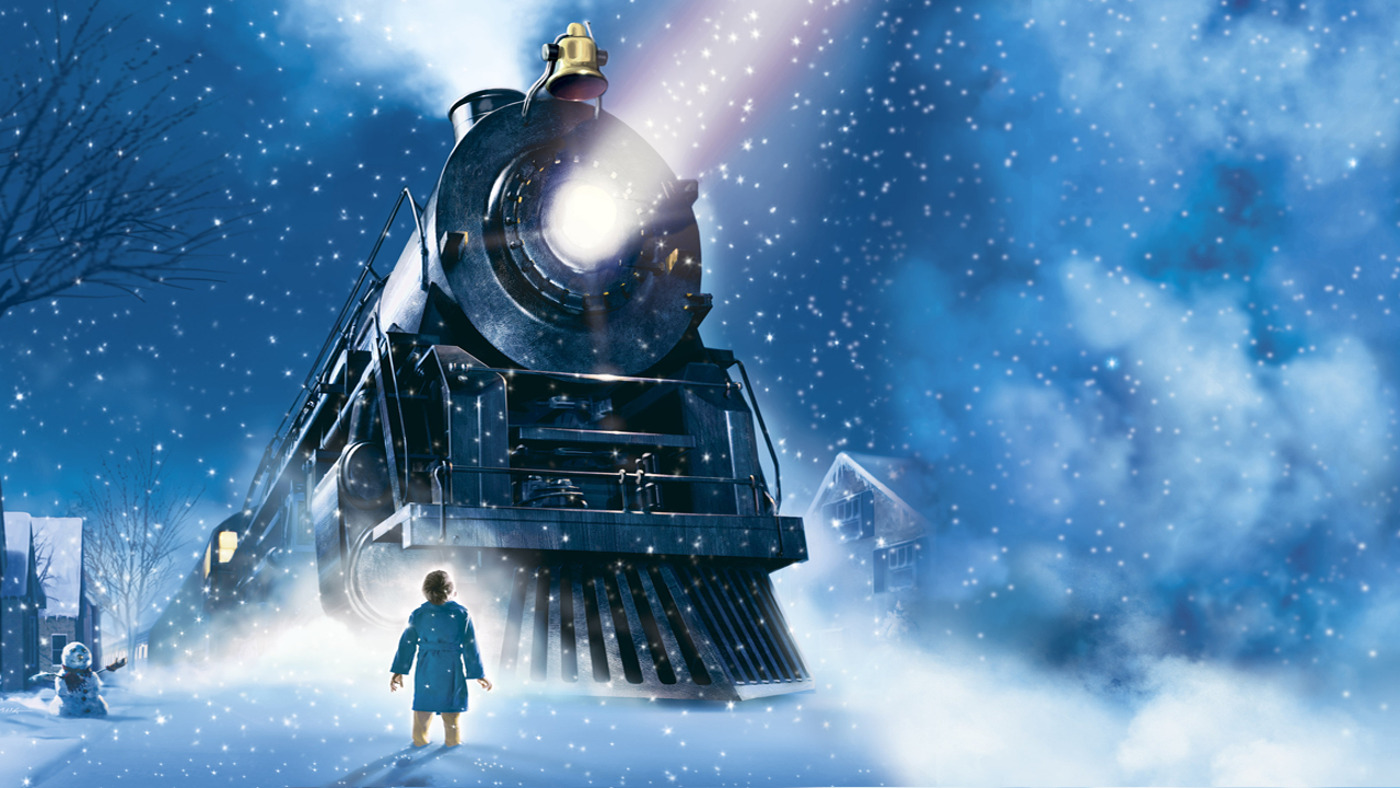 Image of boy in front of train in the snow.