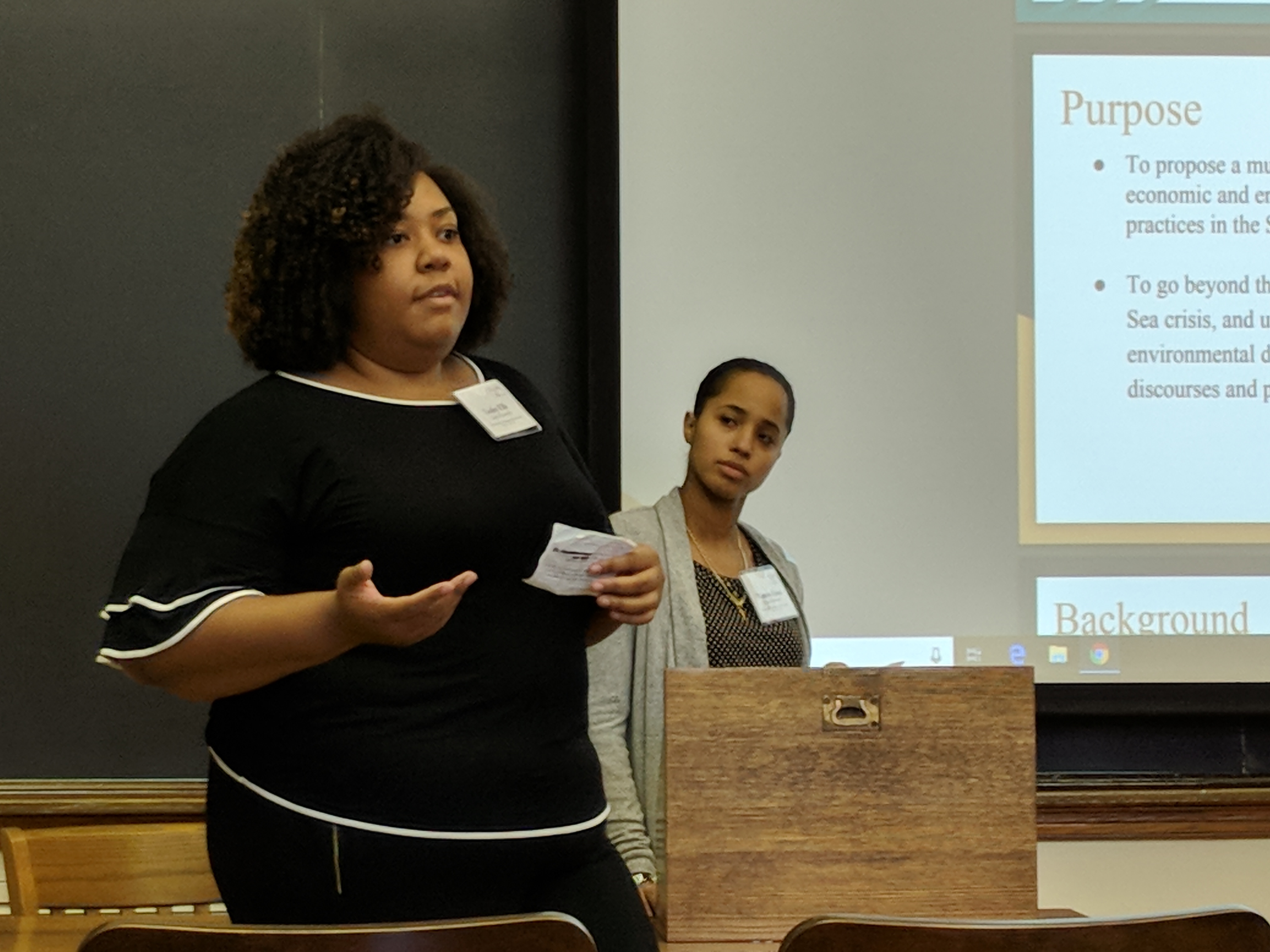Students Lesley Ells and Tamara Grant deliver a presentation in front of a PowerPoint at the Yale Policy Competition
