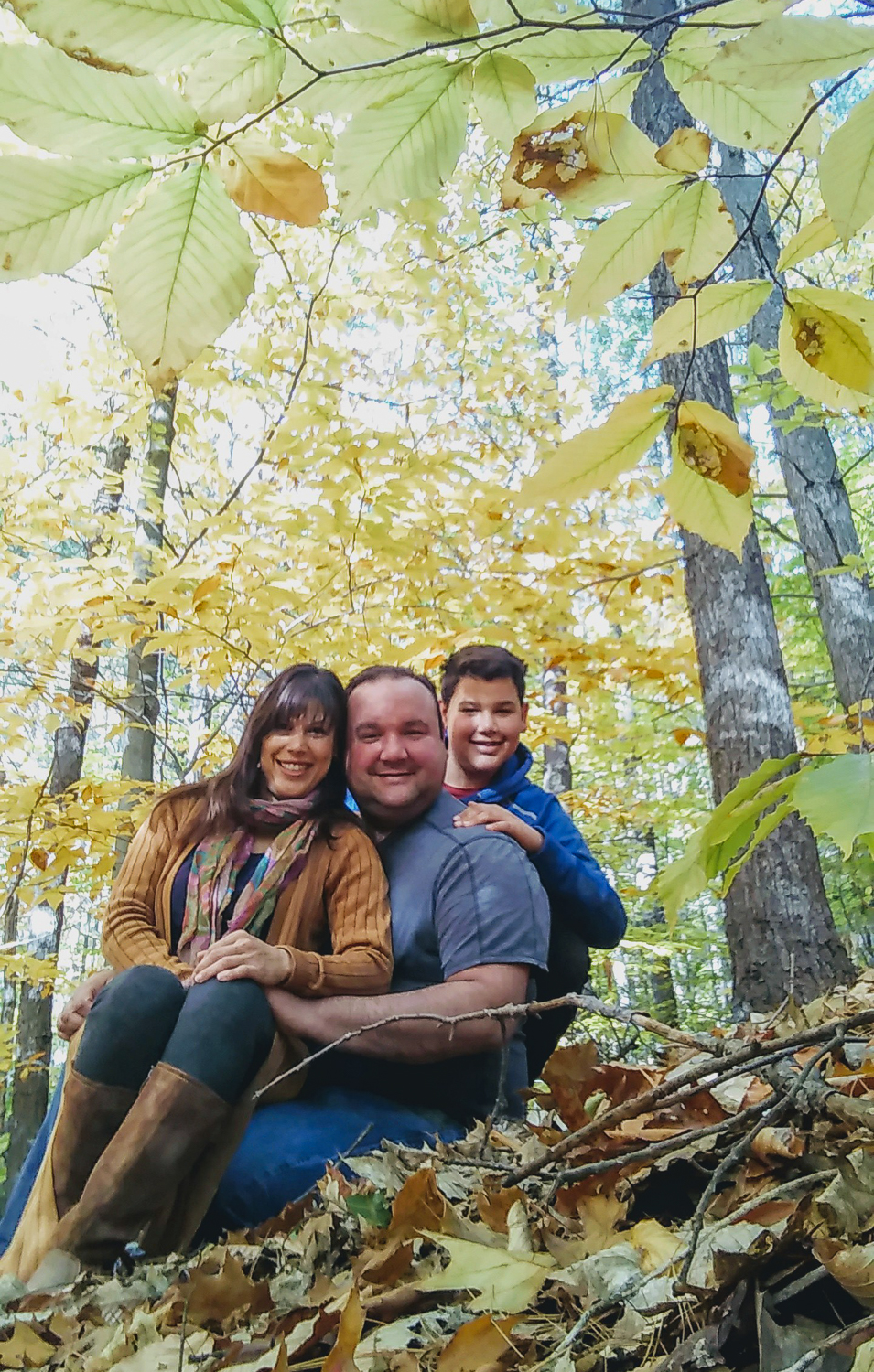 Photo of Yvonne Sierra with her husband and son, taken in the woods in autumn