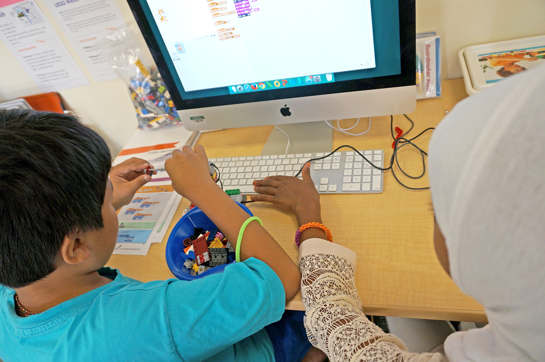 students working at computer collaborating on a coding project