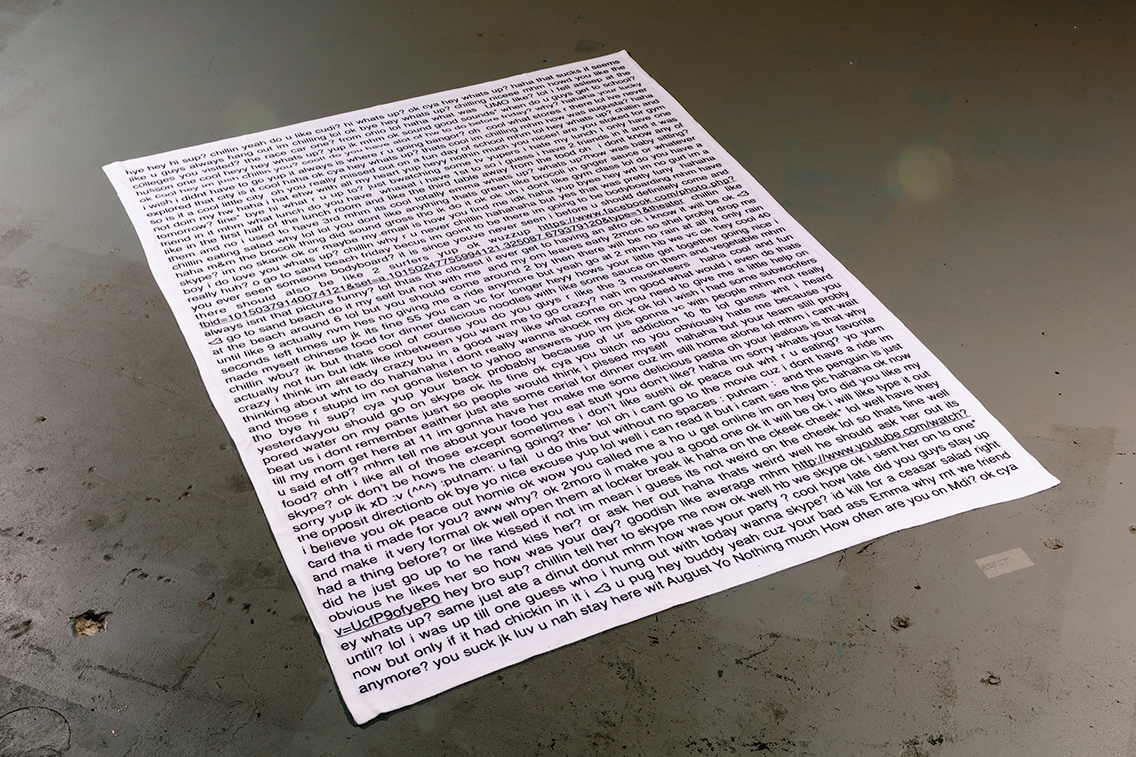 white blanket on concrete floor with black text from private messenger printed on blanket