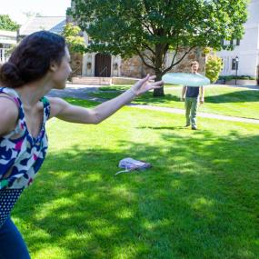 Four students tossing a frisbee on Lesley's campus.