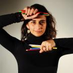 Headshot of Sarah Rubenstein in a black turtleneck holding pencils