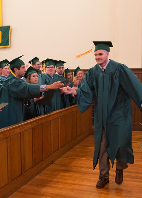 Graduate Chris Satterfield receives a high five as he approaches the stage.