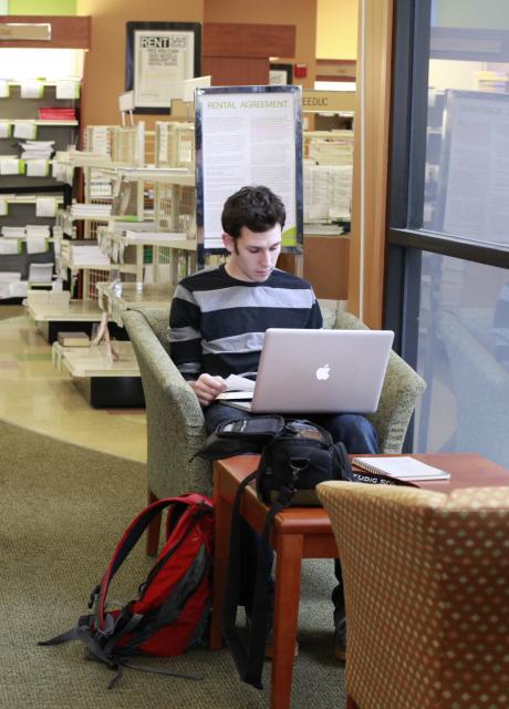 student working on laptop in lesley university bookstore