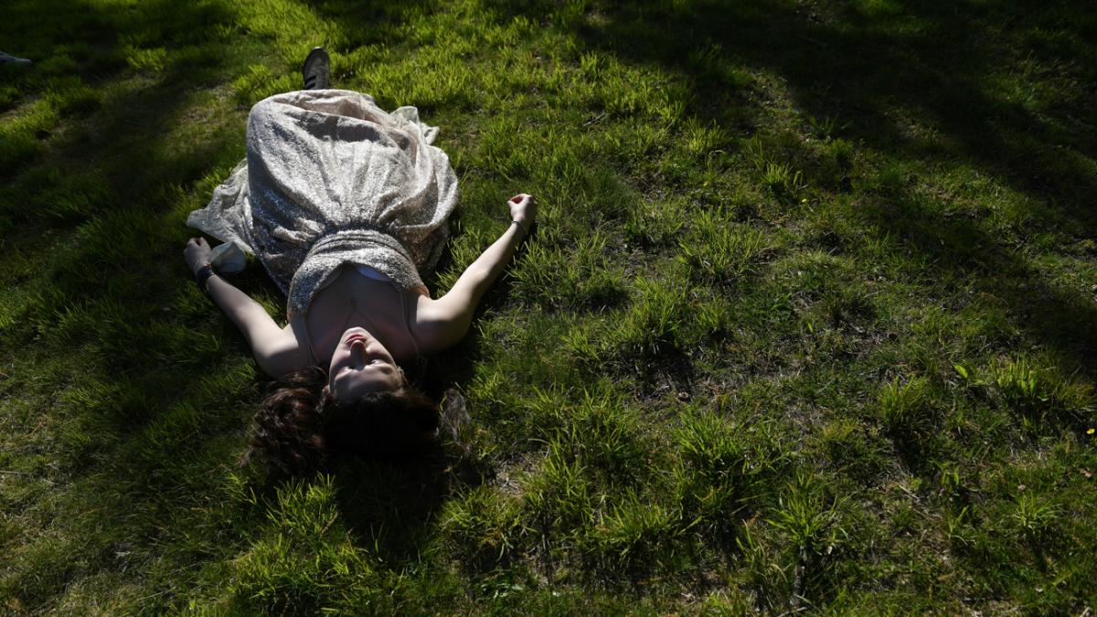 Girl laying on the grass in a prom dress