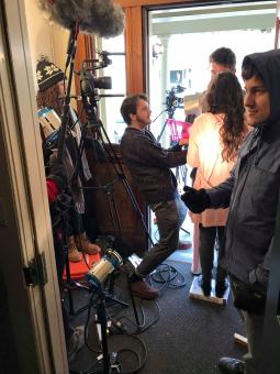 a film crew prepare for a shot in a small doorway