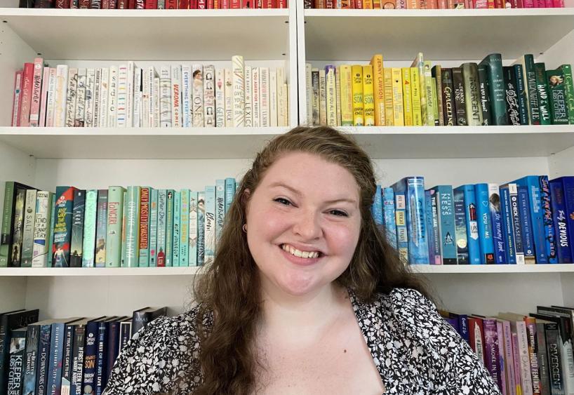 alumna annalise errico smiling in front of a bookcase