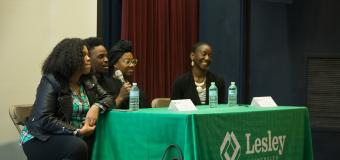 four people sitting at a Lesley University table, taking turns speaking into a microphone