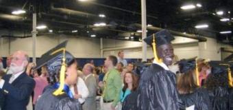 Aleer Deng smiling at camera while in procession at Commencement