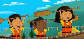 Molly of Denali in a canoe with two friends on the water. They're all raising their oars above their heads.