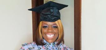 A photo of Rachelle Laine with her graduation cap. She is wearing a light blue floral long sleeve dress.