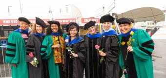 Graduate students pose along the waterfront at Commencement