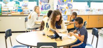 teacher helping student at a desk