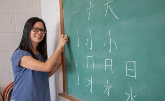 Ruiming Huang teaches Chinese characters at a blackboard