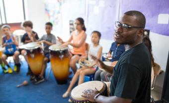 Jonathan Mande leads a drum workshop with elementary students