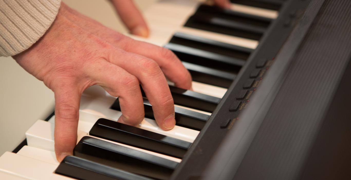 elderly hands playing a piano