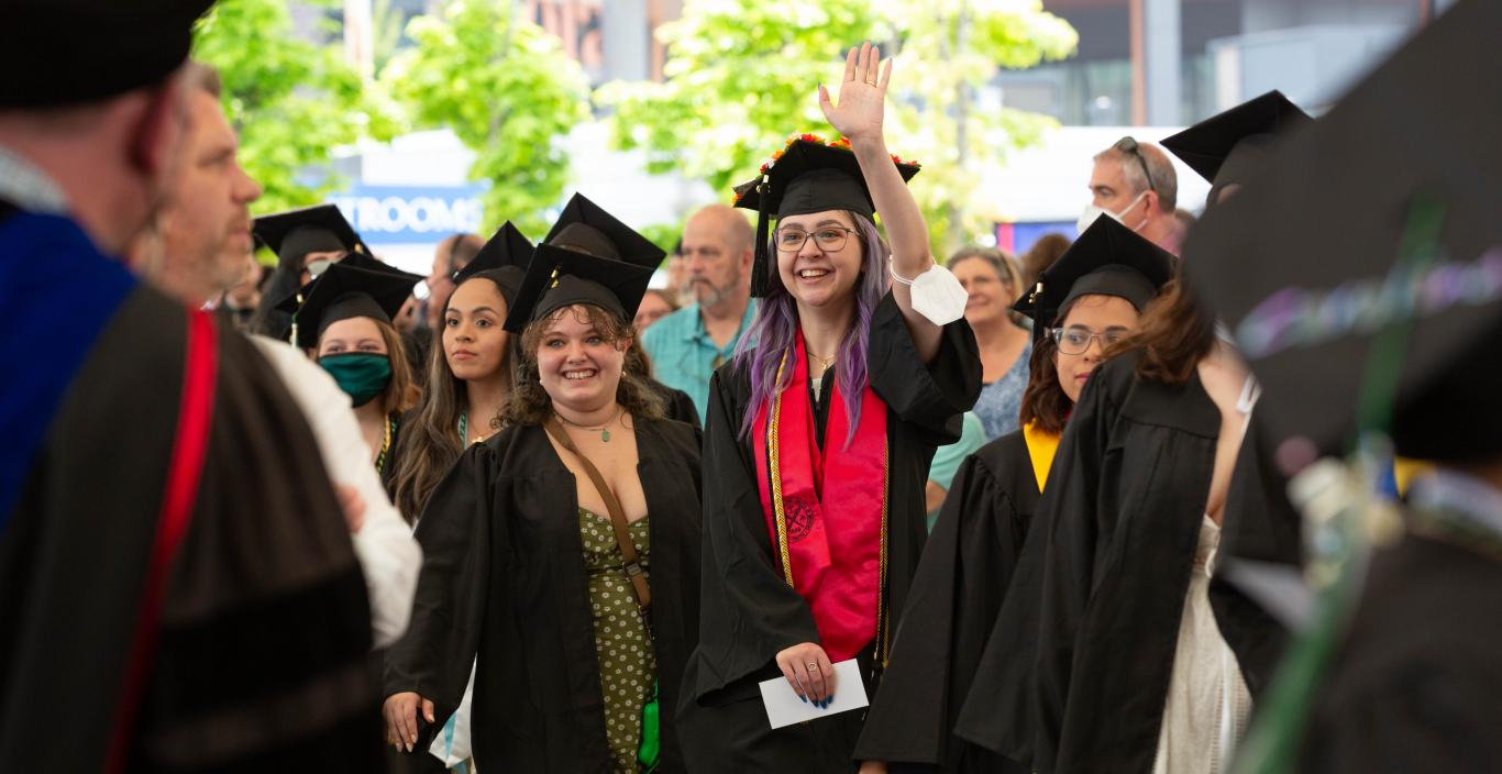 graduates greet people during commencement
