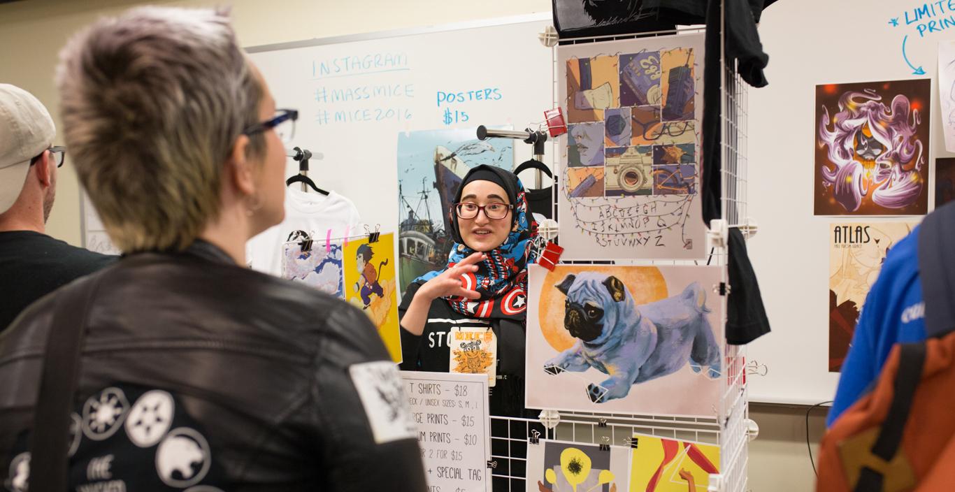 student selling artwork speaking to customer