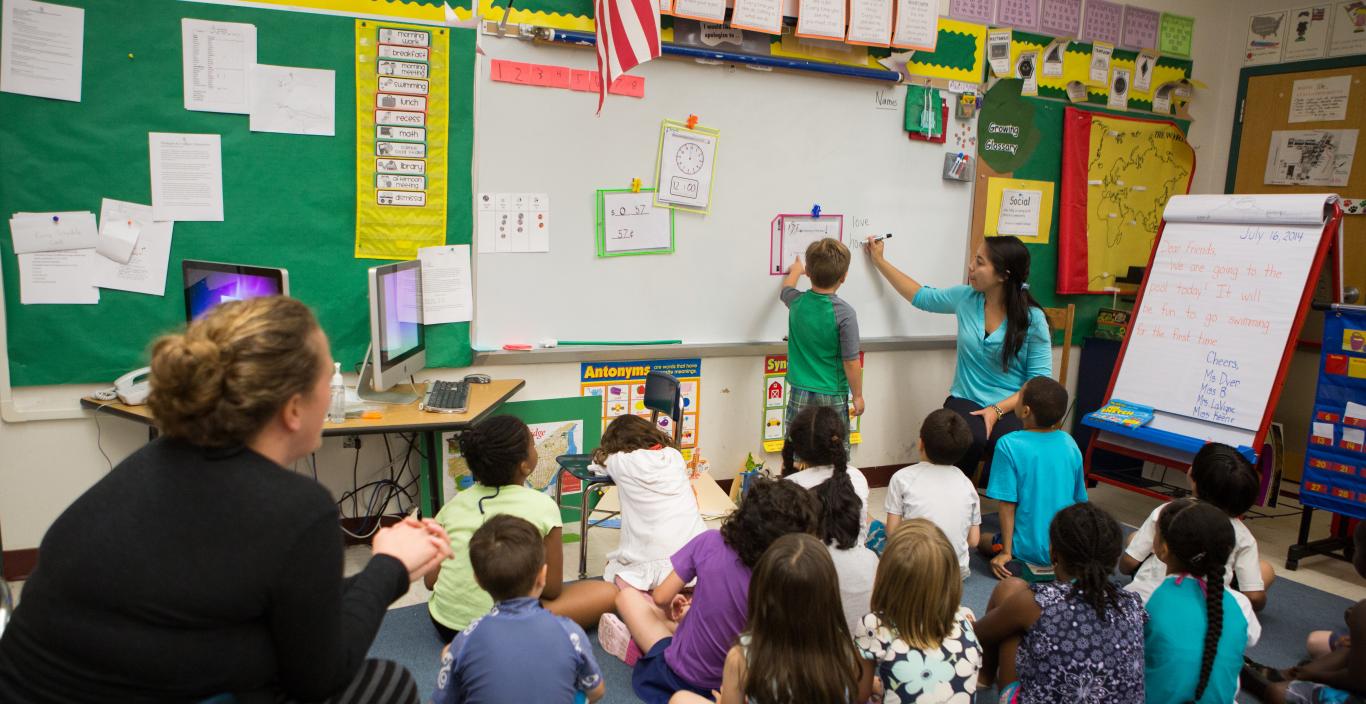 teacher teaching small children at a board