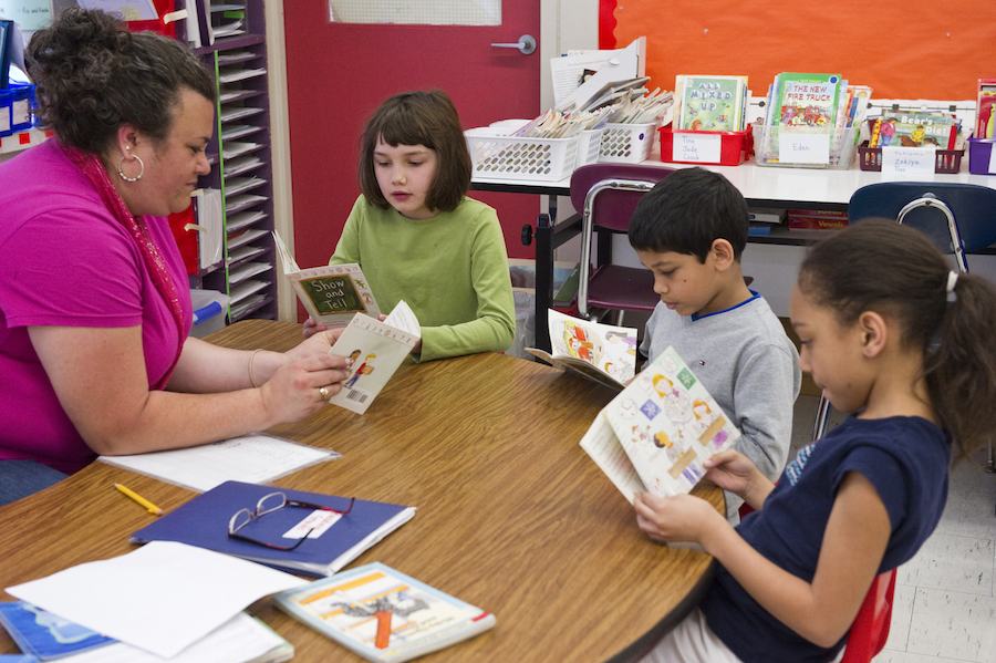 Teacher reading to a small group of students 