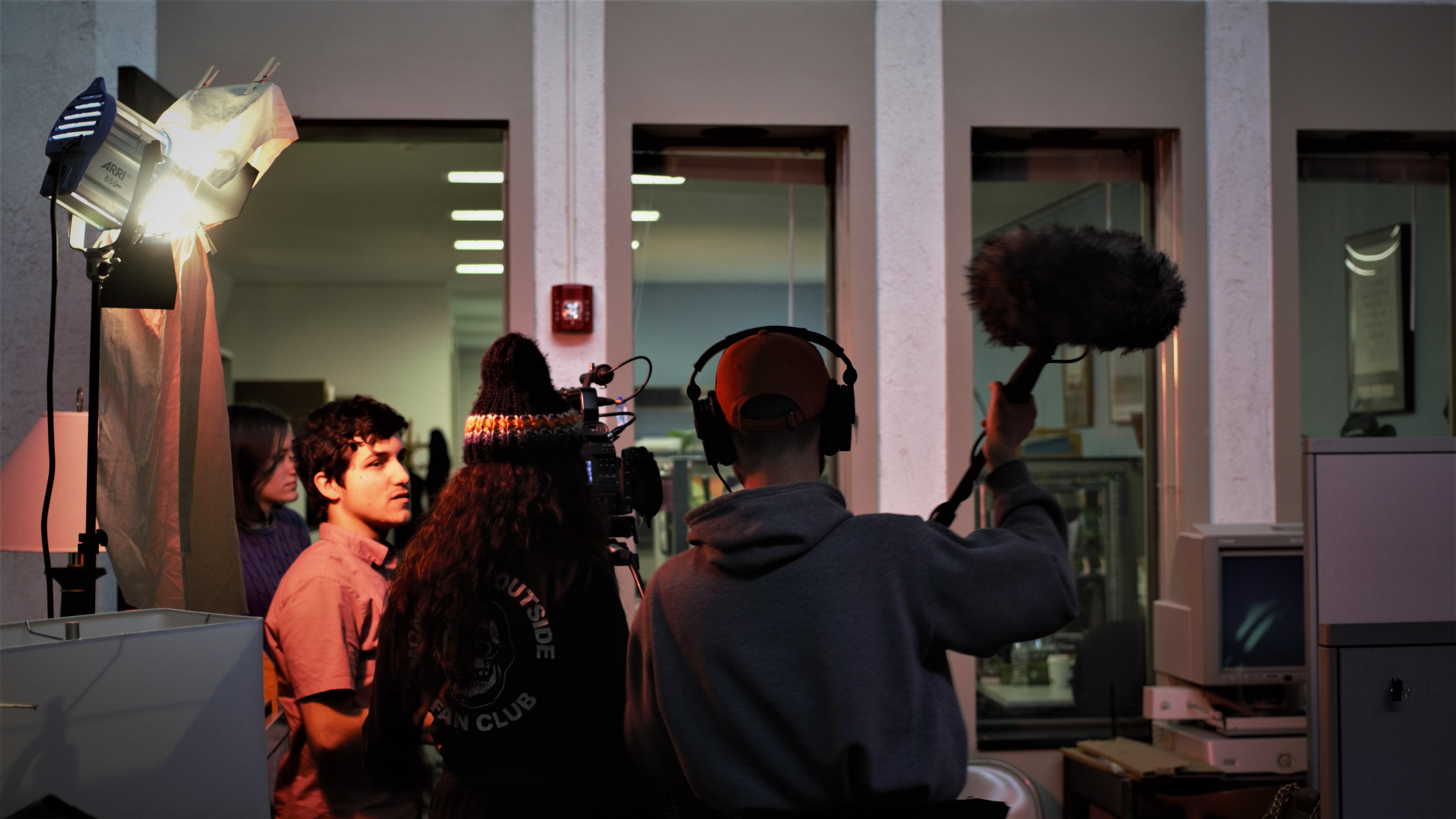students on set with boom mic, camera, and spotlights