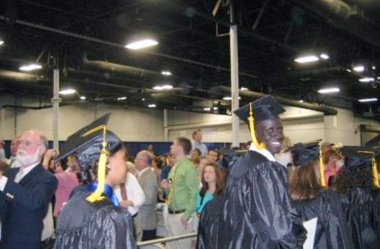 Aleer Deng smiling at camera while in procession at Commencement