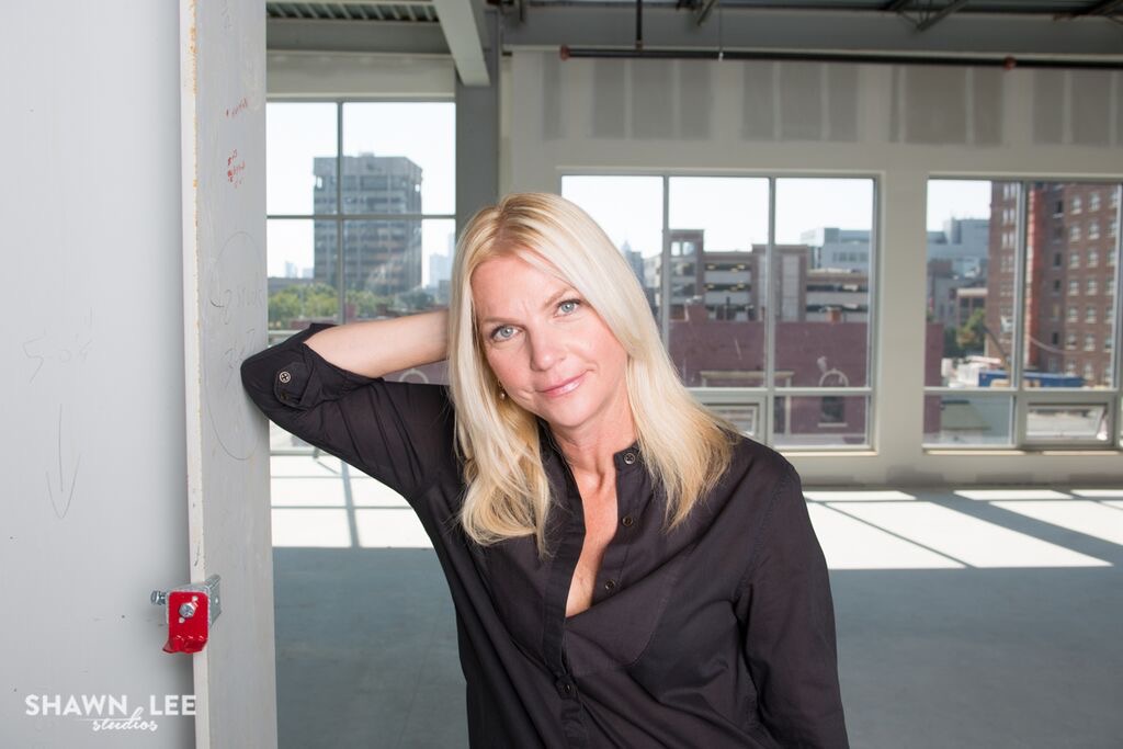 Photograph of new College of Art and Design Dean Amy Green Deines leaning up against a wall.
