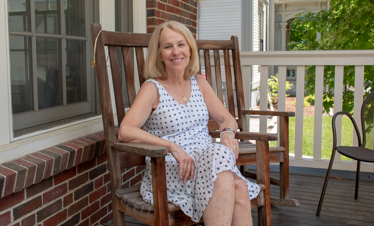 Anusia Hirsch sits in a rocking chair on the porch of one of the dorms.