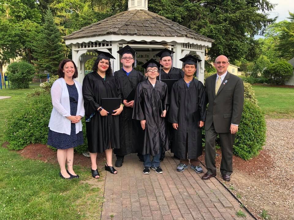 Bert Carter on far right with graduates in their caps and gowns