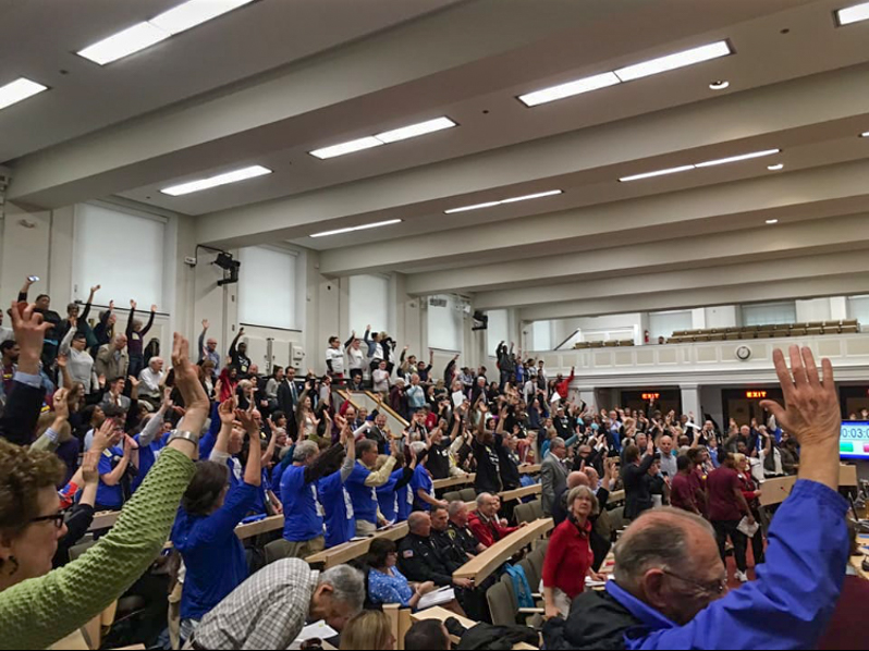 Massachusetts legislators raise their hands to show support after McMillan speaks on behalf of Teens Leading the Way.