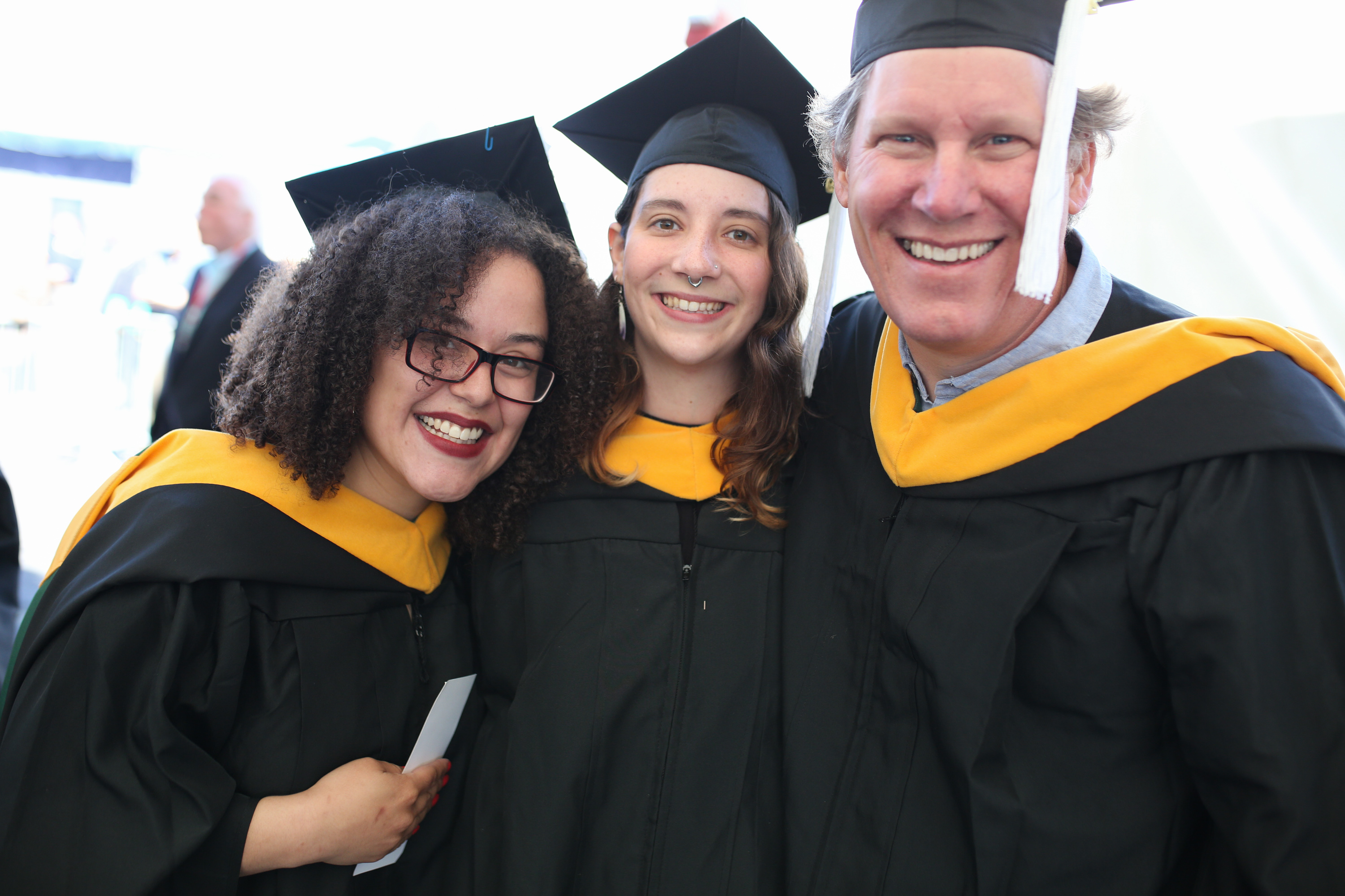 Three graduates smiling for the camera.