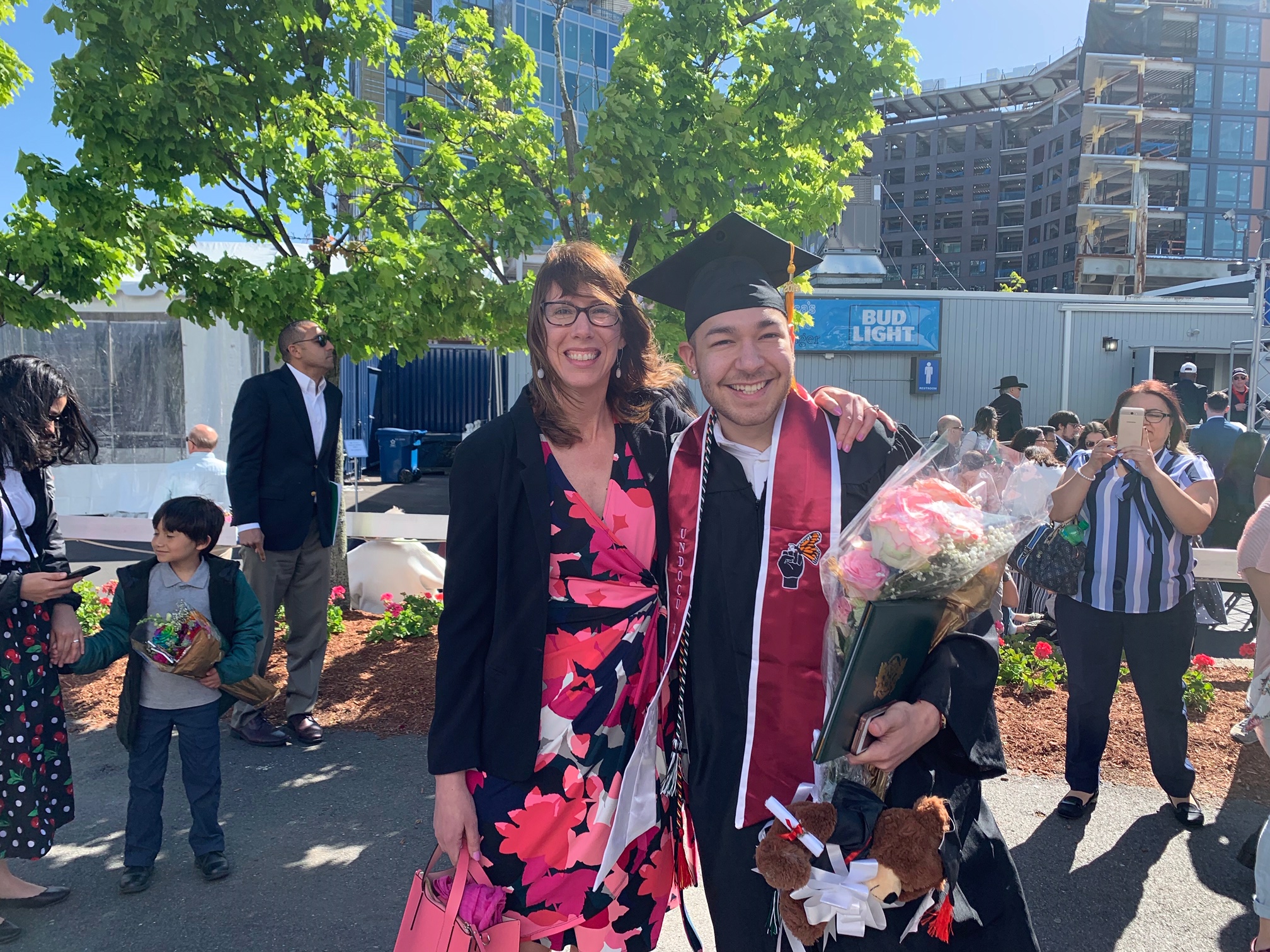 A woman and a young man in his graduation cap and gown posing for a photo on Lesley graduation day 2019.