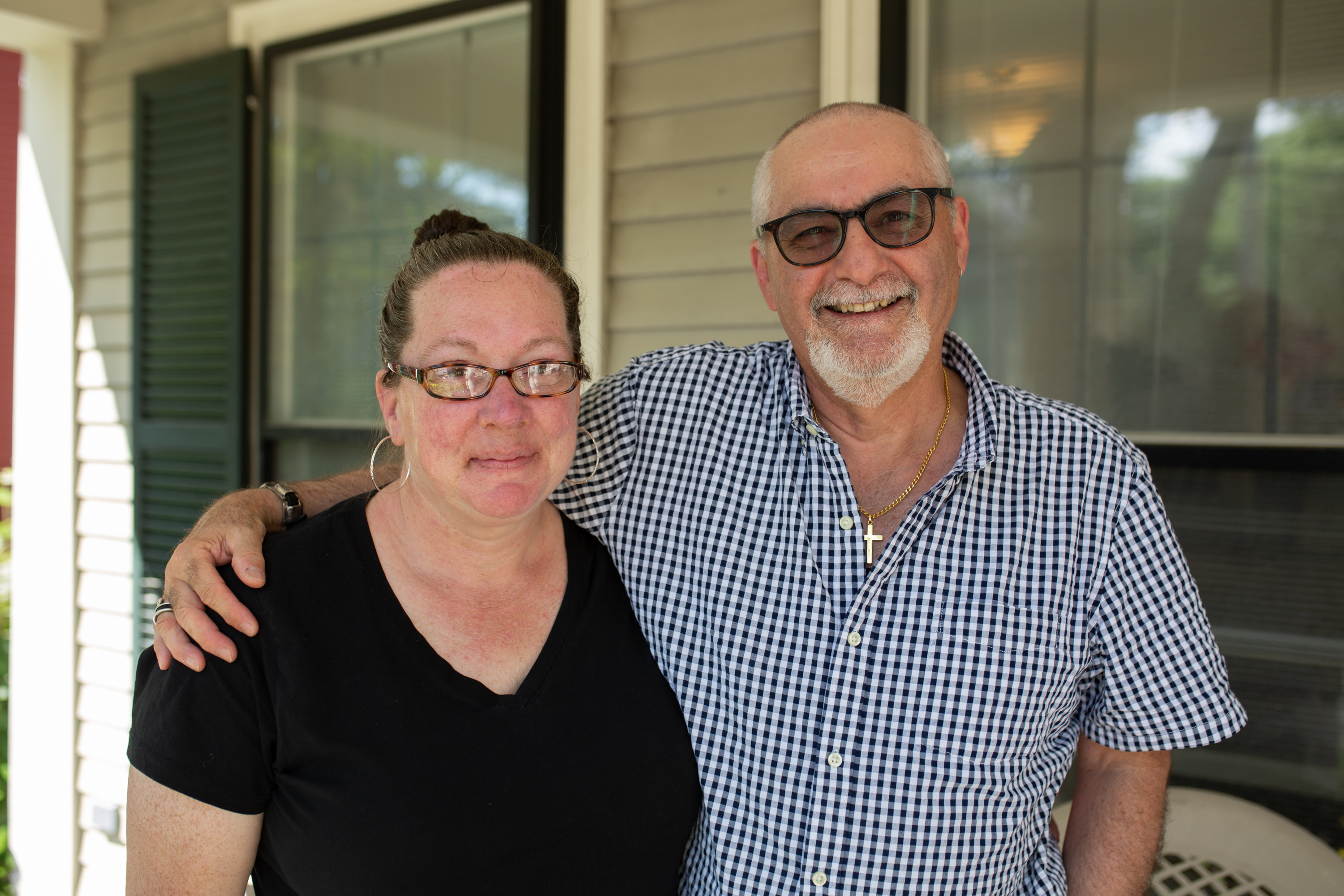 Gene Ferraro stands with his arm around Maryann Broxton on the front porch of the Center for the Adult Learner