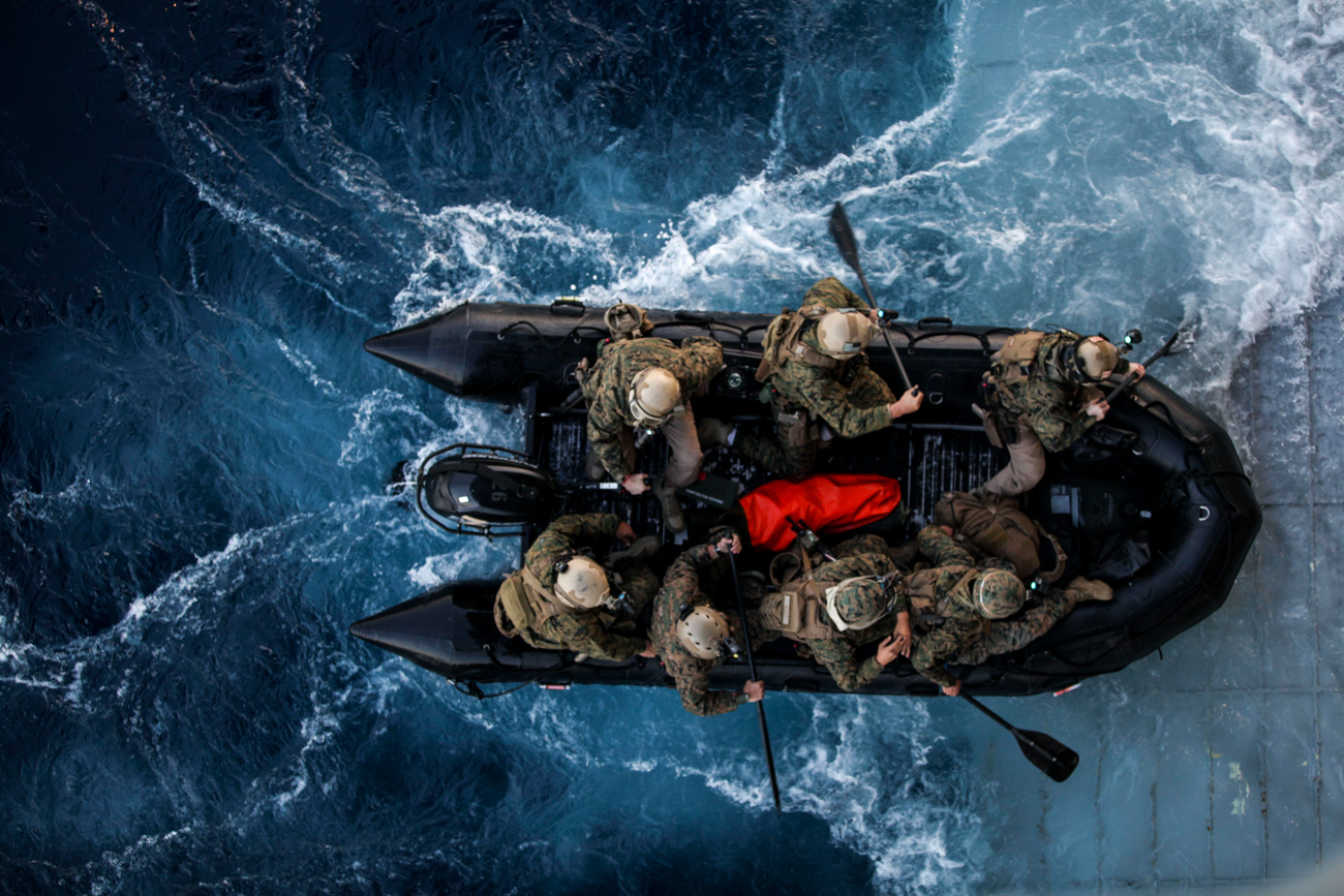 Overhead photo of troops in an amphibious vehicle on the sea.