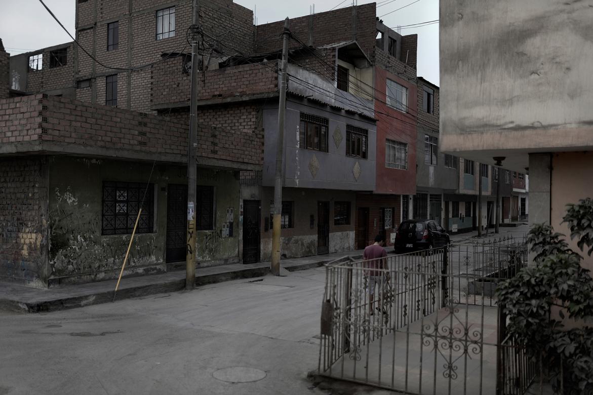 photograph of run-down city neighborhood street with gray skies in the background