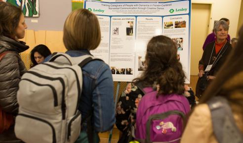 Participants listen to presenter talk about her poster topic