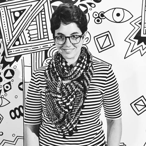 Black and white image of Kate Castelli standing in front of illustration of various lines and shapes