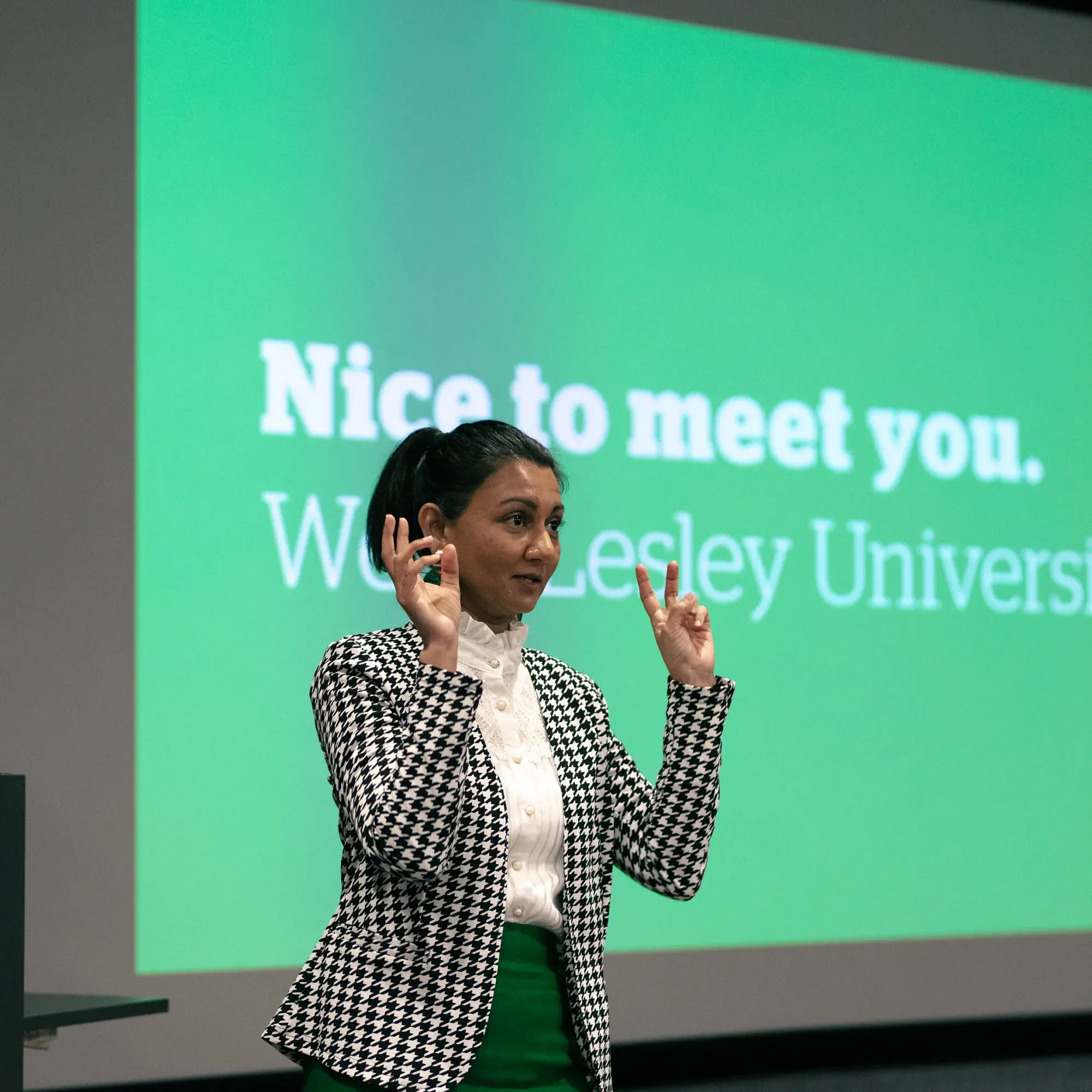 Woman standing in front of "Nice to meet you" welcome presentation