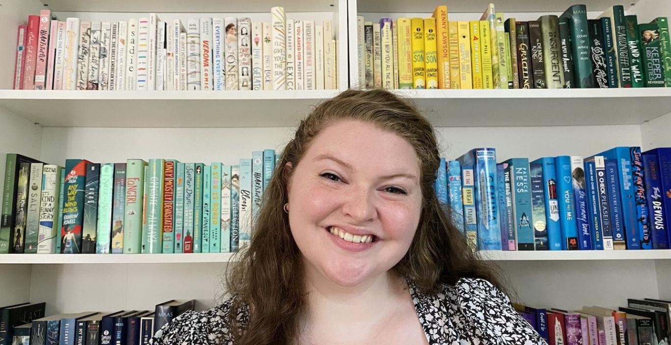 alumna annalise errico smiling in front of a bookcase