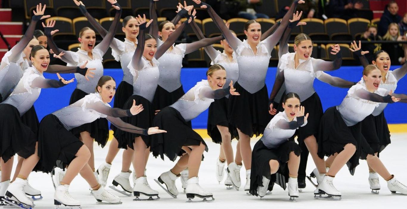 The Haydenettes - in costume on the ice. Hands out and smiling for group picture.